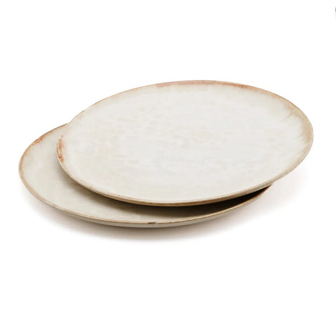 Two round, ceramic plates with a subtle off-white, slightly speckled finish and lightly weathered edges—expertly crafted Portuguese ceramics—stacked partially on top of each other on a white background.