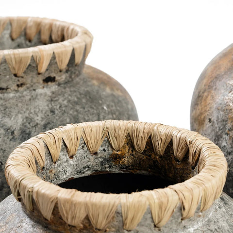Close-up of three Styly Vases in Antique Grey (Medium), each with a rustic, weathered look and rough texture. Light-colored straw wraps around the rim in a zigzag pattern, adding decorative charm to the terracotta design.
