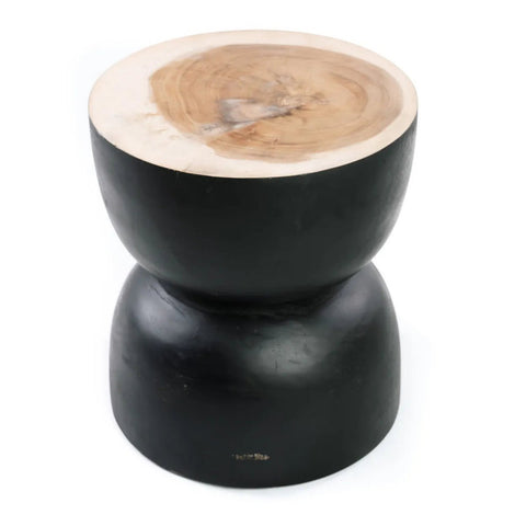 A wooden stool or side table with a natural wood top and a smooth, black suar wood hourglass-shaped base, photographed against a white background.