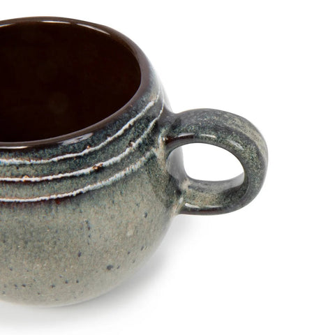 Close-up of a ceramic mug with a rounded body and handle, featuring a smooth, speckled gray-blue glaze and dark brown interior, crafted in the style of Portuguese ceramics and set against a white background.