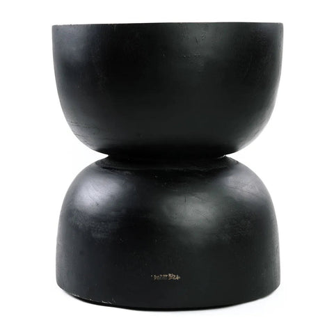 A modern, black suar wood hourglass-shaped side table or charcoal stool with a smooth, matte finish and simple, minimalist design—perfect for lovers of handmade furniture.