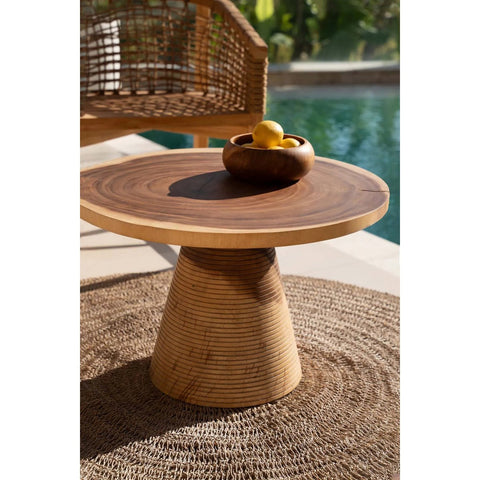 Wooden side table with a bowl of fruit on a patio near a pool