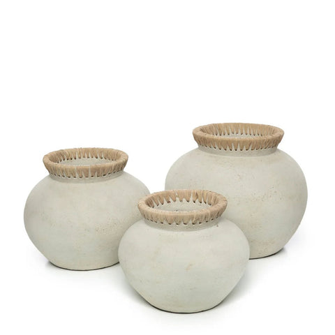 Three round, off-white The Styly Vase - Concrete Natural - M pieces with wide bodies and narrow openings, each topped with a woven natural fiber rim, are arranged side by side on a white background for an eco-friendly look.