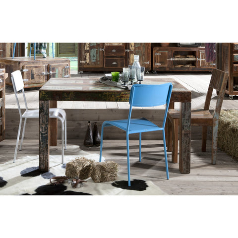 A rustic dining area with a wooden table, three mismatched chairs, glassware, hay bales, a cowhide rug on wooden floors, and country-style decor is complemented by the Industrial Low Board Woodz for added charm.