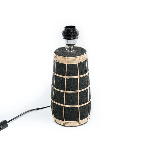 The Naxos Table Lamp - Black Natural features a black textured base with a light rattan grid pattern, an exposed bulb socket, and a black power cord, shown against a white background.