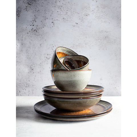 A set of four Comporta Dinner Plates in rustic Portuguese ceramic, featuring earthy tones and a crackle glaze, is arranged on a light surface against a textured gray background, creating a balanced display.