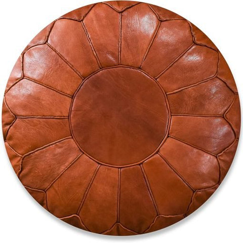 The Leather Pouffe - Cognac Shiny XL is a round, brown leather ottoman featuring stitched segments radiating from the center, forming a flower-like design.