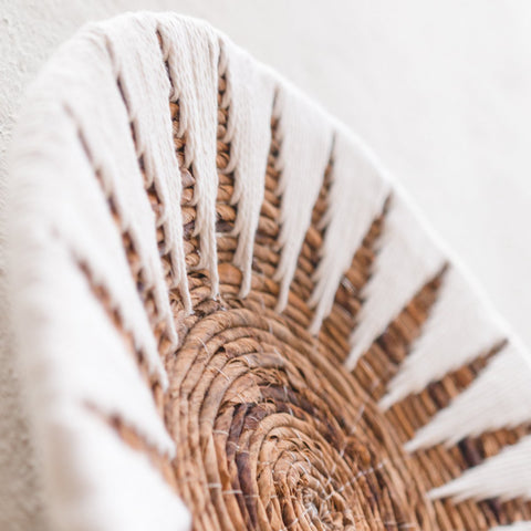 A close-up of the Decorative Bowl MADALA, crafted from natural brown and white fibers with a circular sunburst pattern—ideal as boho wall décor to showcase texture, artistry, and a natural decor style.