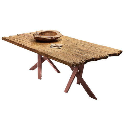 The Woodz Table 200x100 cm features a unique wooden top with uneven edges and intersecting legs. A shallow wooden bowl and a small rectangular item atop the table enhance its rustic charm.