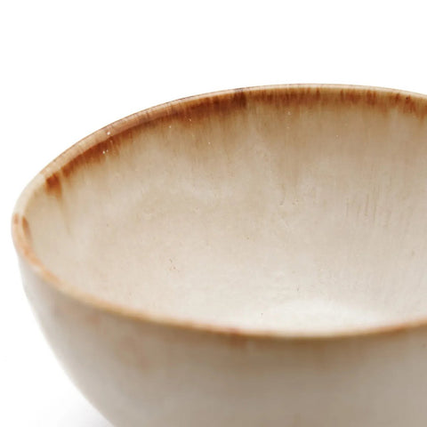 A close-up of a handmade ceramic bowl with a beige, slightly rough surface and brownish rim, showcasing the timeless appeal of Portuguese ceramics against a plain white background.