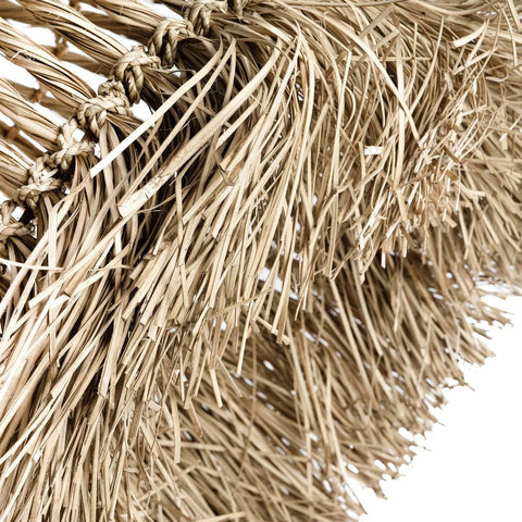 Close-up of dried, straw-like thatch woven together, resembling the textured strands used in The Guagua Pendant - Natural - L, set against a white background.