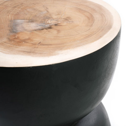Close-up of a round handmade furniture piece—a smooth, natural wood top on a black suar wood base with a matte finish—photographed against a white background.