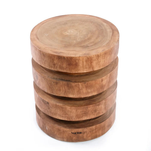 The Massaka Stool - Natural features a round suar wood design with a natural finish and grooved, layered sides like stacked discs. Its smooth top and rustic look make it a sturdy, stylish addition to any space.