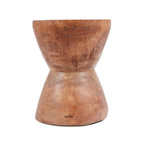 The Kona Stool - Natural is an hourglass-shaped seat crafted from Indonesian suar wood, featuring a smooth finish and natural wood grain—ideal as a stylish stool or unique side table.