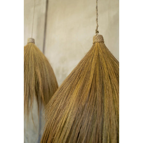 Close-up of two Rayung Hut Pendant lights or decorative objects made from straw or dried grass, with binding at the top and a neutral, blurred background.