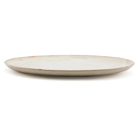 A plain, round, cream-colored ceramic plate with a slightly raised edge, crafted from durable Portuguese ceramics and shown from a side angle against a white background.