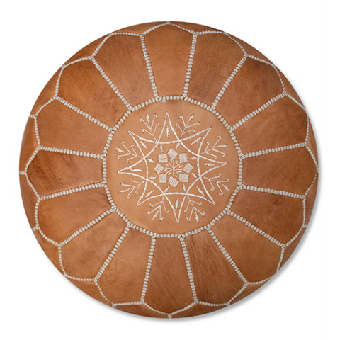 The Leather Pouffe - Natural Brown XL is a round tan leather seat with white geometric and star stitching on top, featuring petal-like sections—a stylish, handcrafted Moroccan accent for your space.
