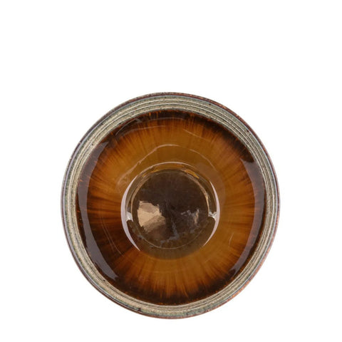 A top view of a ceramic tea bowl with a glossy brown glaze that radiates outward, creating a warm, sunburst-like pattern—an exquisite example of handmade tableware inspired by Portuguese ceramics.