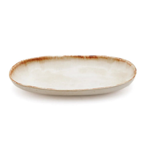 Oval ceramic plate with a slightly raised rim and a light beige glaze, featuring a brown, rustic edge. This handmade tableware piece is empty and set against a plain white background.