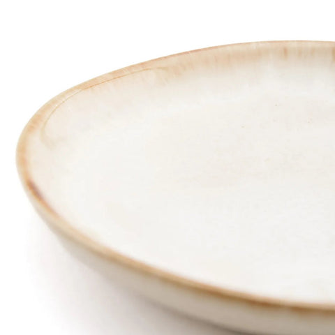 A close-up of The Cascais Appetizer Plate (Set of 6), featuring a slightly irregular edge, light beige speckled glaze, and subtle brown rim—an elegant piece of handmade tableware inspired by Portuguese ceramics.