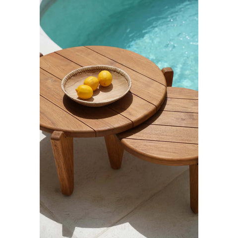 The Seseh Coffee Table - S - Outdoor sits by the pool, paired with a matching small table. A ceramic plate with three lemons is placed on the larger outdoor coffee table.
