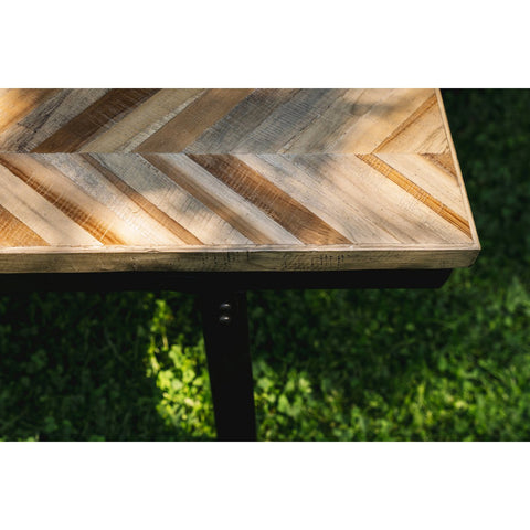 Wooden table with a chevron pattern on a grassy background