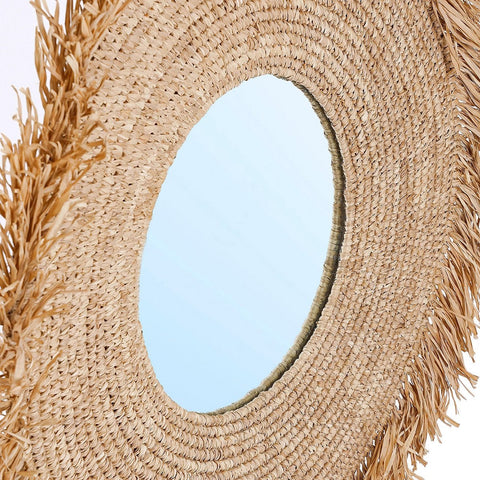 Close-up of a straw mirror with fringes 