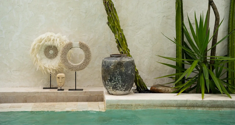 Decorative items by a pool with plants in the background