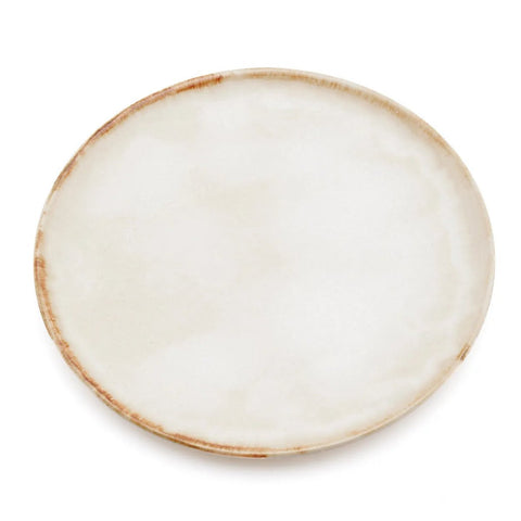 A round ceramic plate with a subtle off-white and beige glaze, featuring a slightly rustic, uneven brownish rim. This handmade tableware piece is photographed empty on a white background.