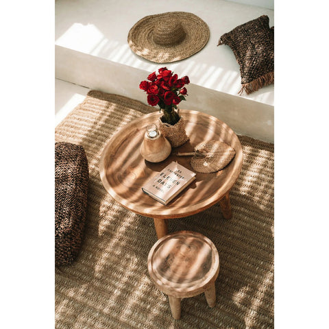 Wooden table with decorative items on a textured rug