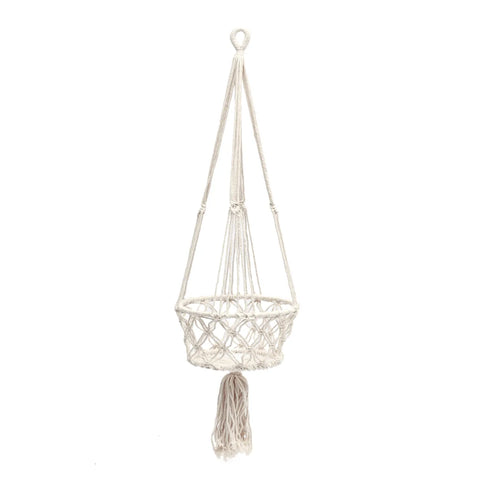 A macrame plant holder with a woven basket design, featuring a knotted fringe at the bottom, hangs gracefully from a looped cord. This white macrame basket is perfect for displaying hanging plants and designed to hold your favorite potted plant securely.