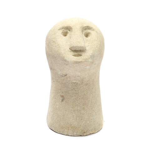 A small, smooth Sumba Stone sculpture resembling a simplified human face with minimal features. This hand-carved figure has a rounded top and an elongated base, set against a plain white background.