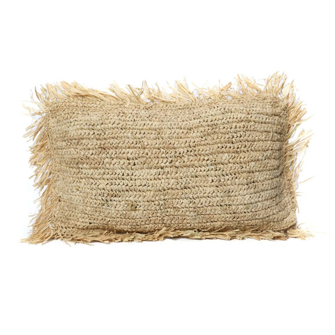 A rectangular boho home pillow made of natural fibers with a textured surface and fringed edges. Handwoven in Indonesia, the straw-colored fibers give this Raffia cushion its rustic appearance.