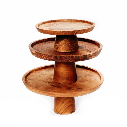 Three-tiered wooden cake stand with circular platforms of varying sizes, featuring a natural wood grain finish. Each tier is supported by a cylindrical base, creating an elegant, rustic look perfect for displaying sweets.