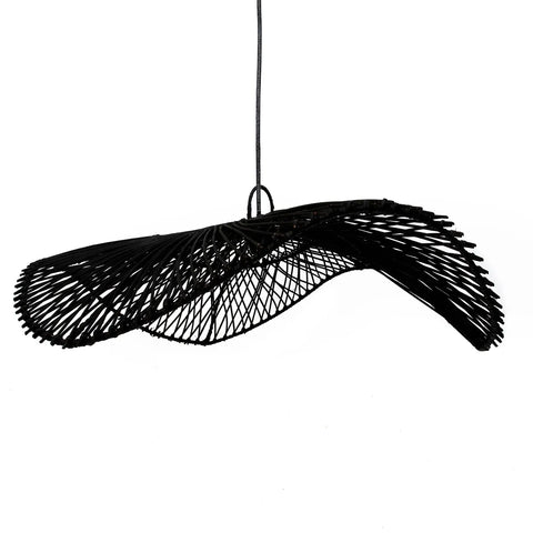 Modern black rattan pendant light fixture with a twisted, open-weave design hanging from the ceiling. Handcrafted with a sculptural, artistic appearance, it creates an intricate play of shadows and adds a boho lamp touch to any space.