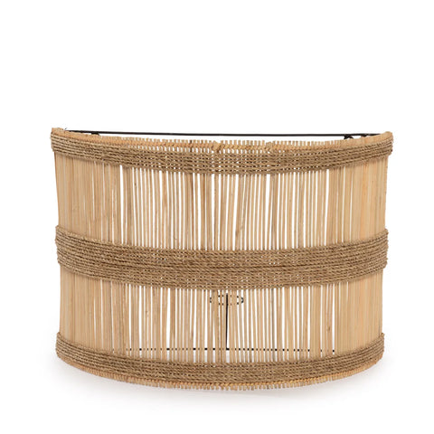 A decorative woven bamboo table with a semicircular shape exudes a coastal vibe. The design, enriched with vertical slats of rattan and two horizontal bands wrapped around it, highlights a natural and rustic style.