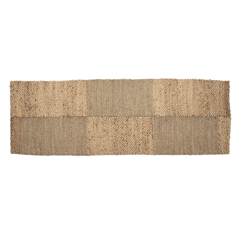 A rectangular jute rug with a checkerboard pattern of natural and darker fibers, reminiscent of a Paddle Field Runner. The texture is coarse, showcasing the woven design in natural tones. The rug is laid out flat against a white background.