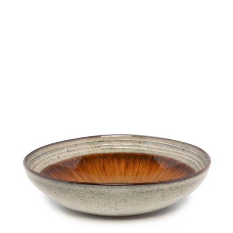 A round, shallow bowl from the Comporta Collection features a speckled gray exterior and a glossy, deep orange interior. The inside boasts a radial pattern reminiscent of a sunburst, enhanced by a crackle glaze finish. The piece is elegantly set against a plain white background.