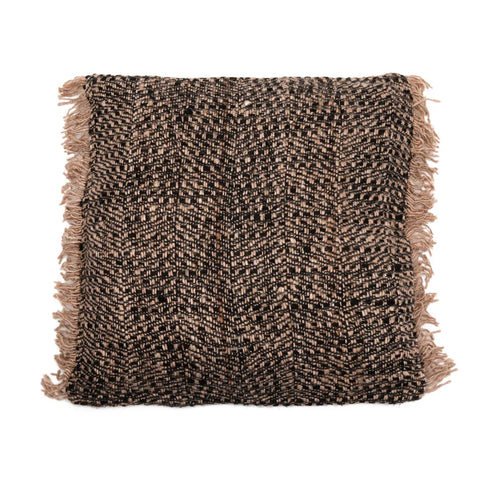 A square cotton cushion with a textured, woven pattern in shades of black and brown exudes a boho vibe. The edges are adorned with beige fringe tassels, enhancing its charm. The thick, cozy fabric adds a decorative touch.