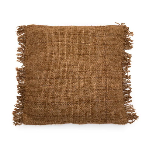 A square brown burlap pillow with frayed edges on all sides, this boho cushion boasts a textured, woven surface with visible fibers.