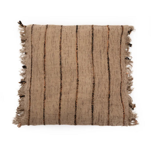 A square beige pillow with vertical brown and black stripes and fringe along the edges exudes a boho vibe. The texture appears woven and rustic, adding to its charm as a handmade textile.