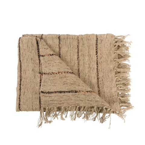 A folded, textured beige cotton throw with dark stripes boasts a cozy appearance. Its edges feature tassels, adding elegance to this luxury hand-woven plaid.