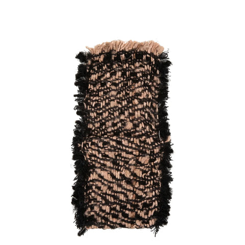 Close-up of a textured rug with a woven pattern in black and tan colors, featuring fringed edges. The luxurious element of thick, soft fibers gives it a rectangular shape that beautifully complements any decor.