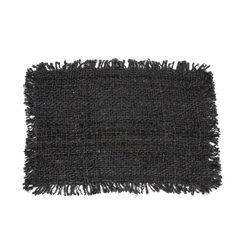 A rectangular black woven rug with fringed edges on all sides, hand-dyed to enhance its luxurious texture, is displayed against a plain white background.