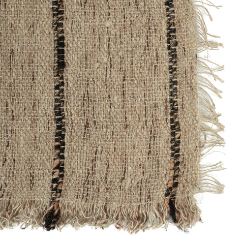 Close-up of a hand-dyed woven fabric with a luxurious texture, featuring a beige background and vertical dark brown stripes. The cotton placemat has fringed edges on the right, enhancing its rustic and textured appearance.