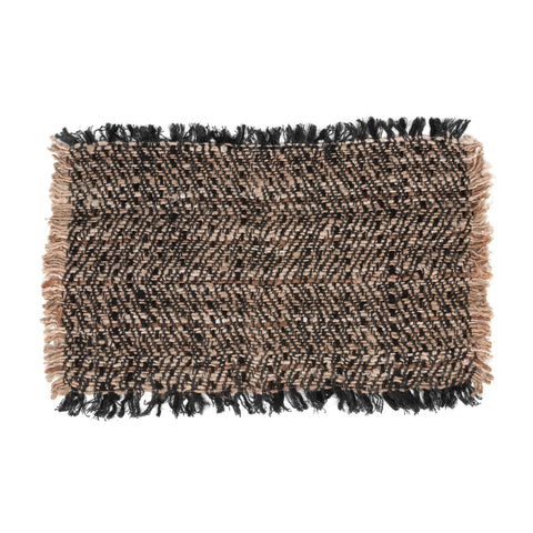 A rectangular woven rug with a luxurious texture in shades of brown and black, featuring a hand-dyed pattern. The edges are adorned with fringe detail.