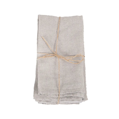 A stack of folded table linen napkins, crafted from 100% linen, is tied together with a simple piece of twine and set against a plain white background.