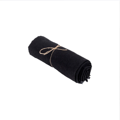 A rolled-up, black table linen secured with a simple brown string, isolated on a white background.