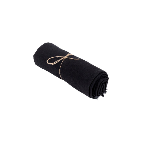 A rolled-up black linen fabric, tied with a thin piece of twine, sits isolated on a white background.