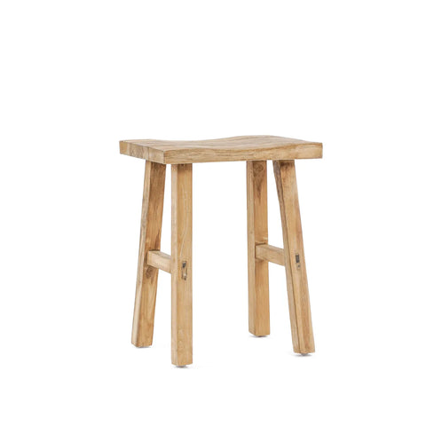 A simple, rustic stool crafted from reclaimed teak wood features a natural finish and a slightly curved seat. It has four sturdy legs and visible wood grain, enhancing its traditional appearance.